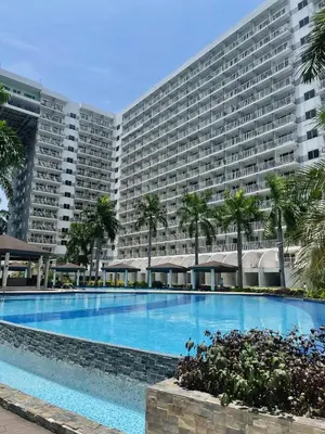 a large apartment building with a large swimming pool at Mall of Asia Staycation in Manila