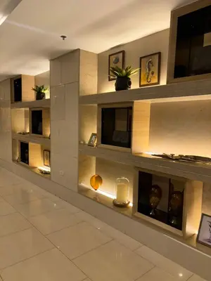a lobby with a wall of shelves with candles at Mall of Asia Staycation in Manila