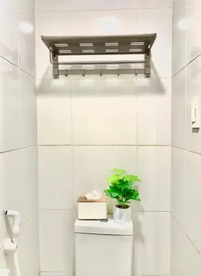a shelf above a toilet with a plant on it at Amari Staycation - Alabang in Manila