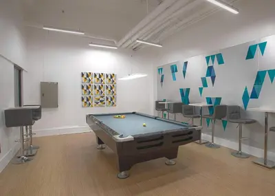 a room with a pool table and some chairs at Amari Staycation - Alabang in Manila