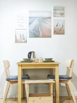 a wooden table with two chairs and pictures on the wall at The Crash Pad Soho Central in Manila