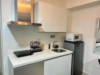 a small kitchen with a sink and a microwave at SM Bicutan Azure Flat in Manila