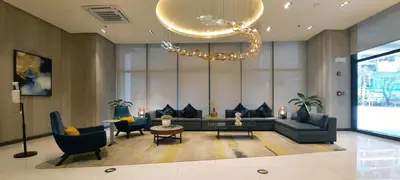 a living room with a couch and chairs and a chandelier at Uptown District Stay in Manila
