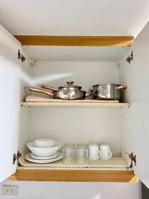 a kitchen shelf with pots and pans and glasses at OASIS by JK Suites in Manila