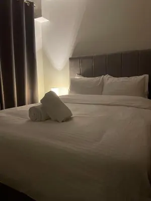 a white bed with a folded towel on it at The Ren Suite Facing Sunrise or City View in Manila
