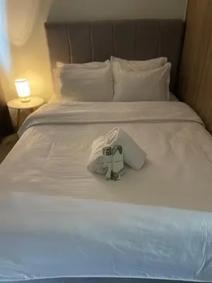 a white bed with a box on top of it at The Ren Suite Facing Sunrise or City View in Manila