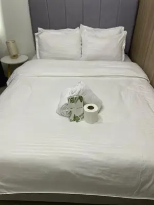 a bed with two towels and a roll of toilet paper at The Ren Suite Facing Sunrise or City View in Manila