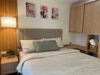 a bed in a bedroom with three pictures on the wall at Supreme Luxury 2BR Condo - Azure Urban Resort Residences near Manila Airport in Manila