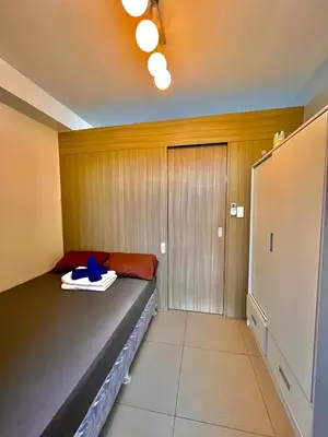 a small room with a bed and a closet at Shore 8109 onebedroomwbalcony in Manila