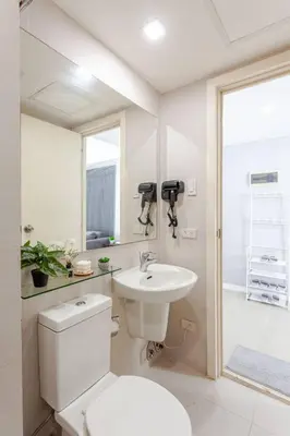 a white bathroom with a toilet and a sink at Cee Staycation in the City - Azure Maui Penthouse in Manila