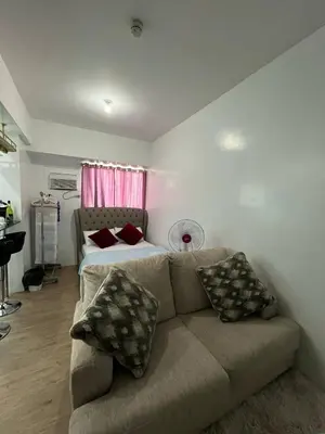 a living room with a couch and a bed at Anuva Condo Staycation in Manila