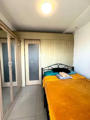 a bedroom with a bed with an orange blanket at Shore 607 A bayview moa in Manila
