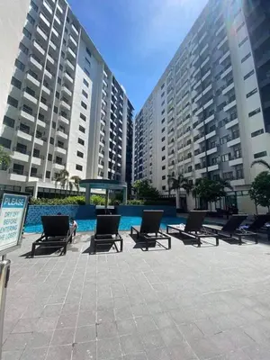a row of lounge chairs in a courtyard with buildings at dream horizon staycation in Manila