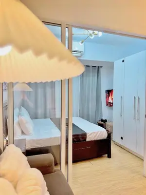 a bedroom with two beds and a couch at Arcadia Suites Manila at Acqua in Manila