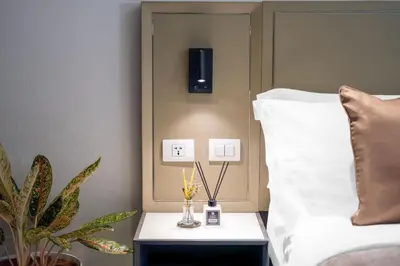 a bedroom with a bed and a nightstand with a side table at Newport Stay by Runway Manila & Attractions in Manila