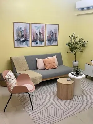 a living room with a couch and a table at Stad en Thuis - Mckinley Hill, Taguig in Manila