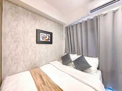 a bedroom with a bed with white sheets and pillows at 1BR Condotel with Balcony at FAME Residences #FM16-1 in Manila