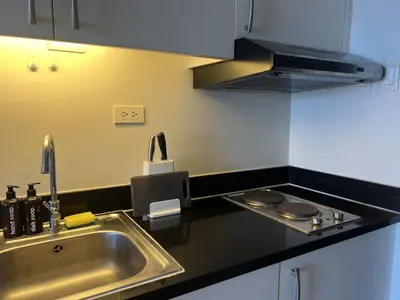 a kitchen with a sink and a stove at Cozy Nook l Accessible LRT QC l Wifi & Netflix in Manila