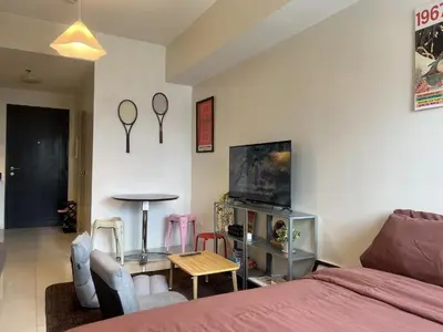 a room with a bed and a table and a tv at Cozy Nook l Accessible LRT QC l Wifi & Netflix in Manila