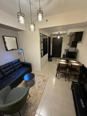 a living room with a blue couch and a dining room at NFr in Manila
