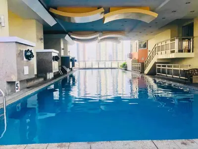 a large swimming pool in a building with blue water at Birch Tower a9 front of Robinson PlaceRizal park in Manila