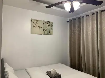 a bedroom with a bed and a ceiling fan at Birch Tower a9 front of Robinson PlaceRizal park in Manila