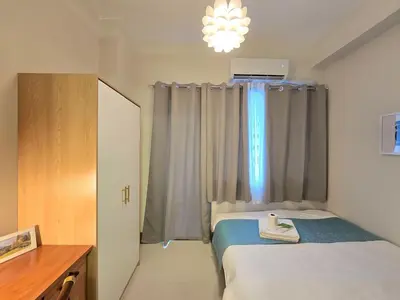 a small bedroom with a bed and a window at 1BR Condotel with Balcony at FAME Residences #FM62-1 in Manila