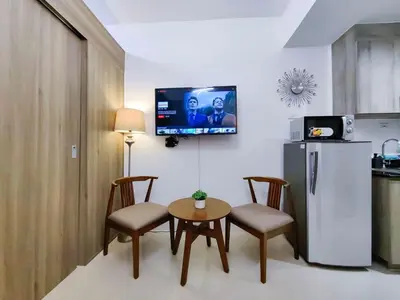 a kitchen with a table and chairs and a refrigerator at 1BR Condotel with Balcony at FAME Residences #FM01-1 in Manila