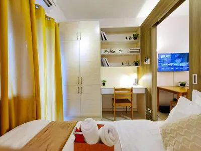 a hotel room with a bed and a desk and a desk at 1BR Condotel with Balcony at FAME Residences #FM02-1 in Manila