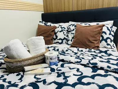 a bed with towels and a basket on it at City Solace in Manila