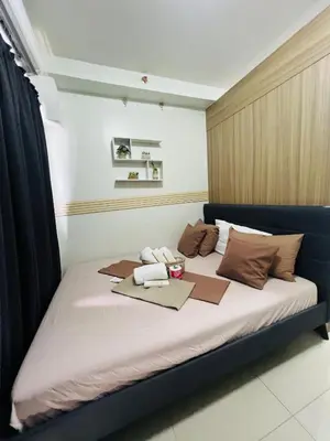 a large bed in a room with two towels on it at City Solace in Manila
