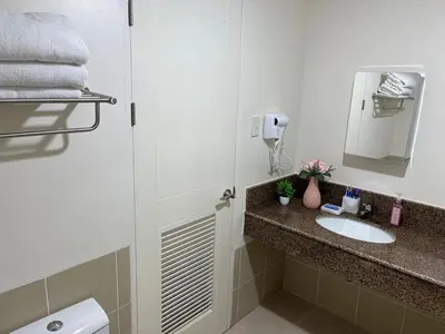a bathroom with a sink and a shower with a mirror at 86 sqm, 3BR condo, Free Prking, WiFi, ntflx in Manila