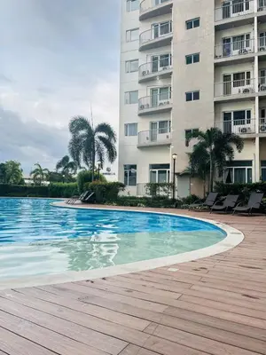 a swimming pool in front of a building at Affordable Condo Near SM Southmall in Manila