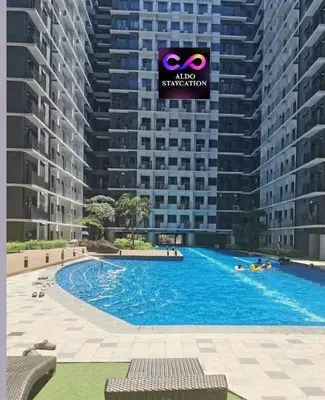 a large swimming pool in front of a large building at Mall of Asia condotel residence shore 3 in Manila