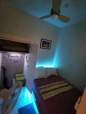 a room with a bed with a ceiling fan and lights at Mall of Asia condotel residence shore 3 in Manila