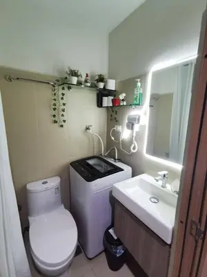 a small bathroom with a toilet and a sink at Mall of Asia condotel residence shore 3 in Manila