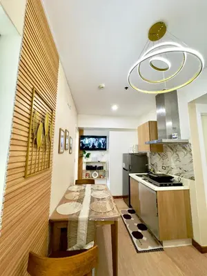 a kitchen with a wooden table and a stove at Positano 933 in Manila