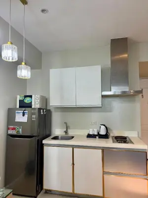 a kitchen with a sink and a refrigerator at Positano 909 in Manila