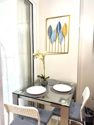a dining room table with two chairs and a glass table at Positano 909 in Manila