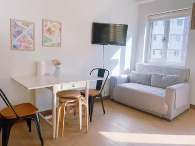 a living room with a table and a couch at Eco Suite Hope Residences Trece in Trece Martires