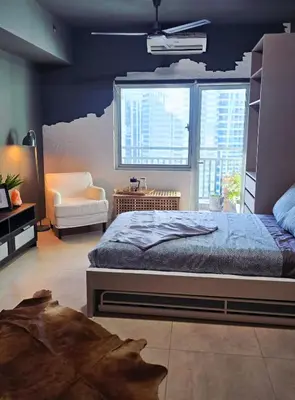 a bedroom with a bed and a large window at QuiHouse in Manila