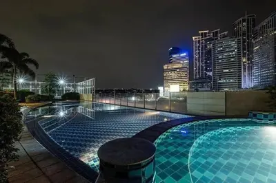 a swimming pool with a city skyline at night at QuiHouse in Manila