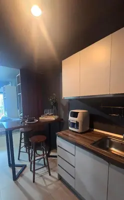 a kitchen with a counter and a table with stools at QuiHouse in Manila