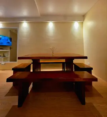 a wooden table with benches in a room at Urban Oasis for 7 with 200 mbps & Netflix in Manila