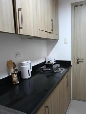 a kitchen with a black counter top and wooden cabinets at Shore moa view in Manila