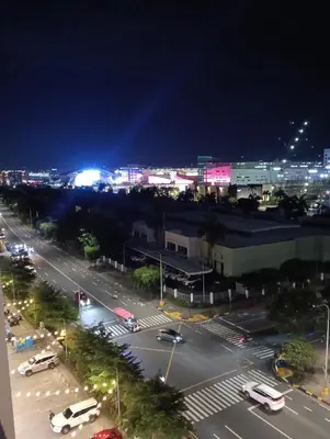 a city street at night with cars on the road at Shore moa view in Manila
