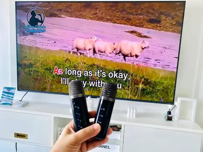 a person holding a remote control in front of a tv at SM Bicutan Condo by Santorini in Manila