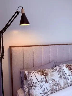 a lamp sitting next to a bed with a pillow at Bright & Cozy High-Rise Condo in Pulong Cacawate