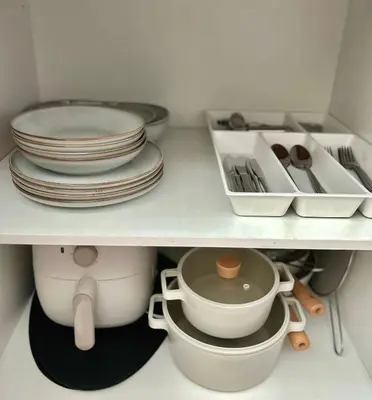 a shelf with plates and utensils in a kitchen at Trescape Studio in Manila
