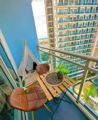 a balcony with a table and chairs on a balcony at SM Condotels by Maui in Manila